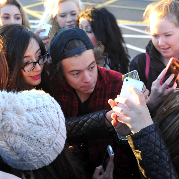 Harry Styles Gets Mobbed By Fans As One Direction Arrives In London See The Pic E Online Uk