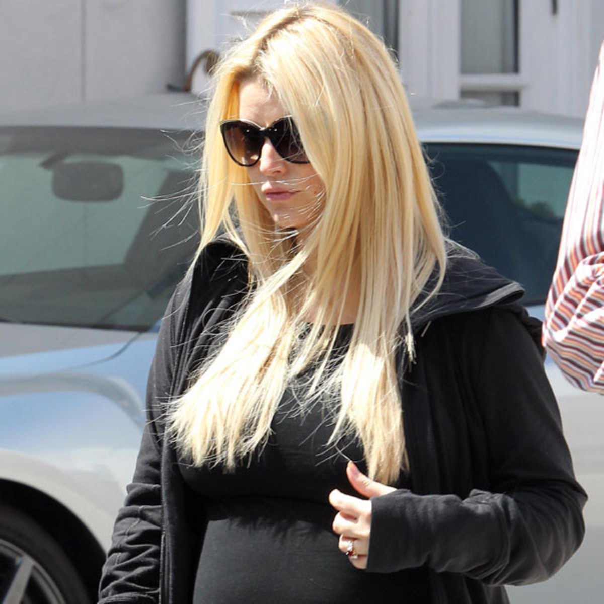 Jessica Simpson cradles large baby bump as she runs errands in  figure-hugging black top and leggings