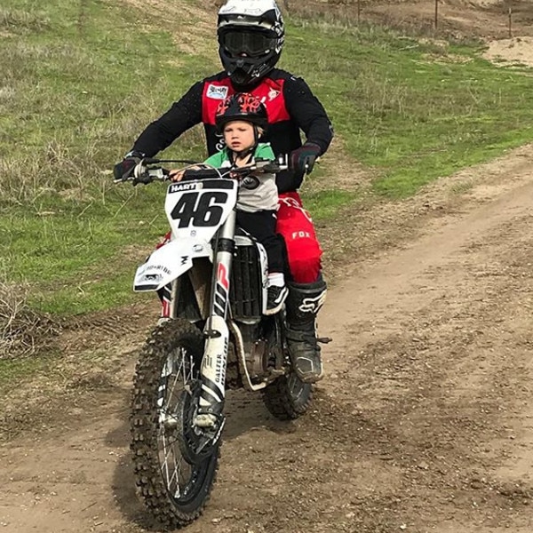 Kid riding cheap motorcycle with dad