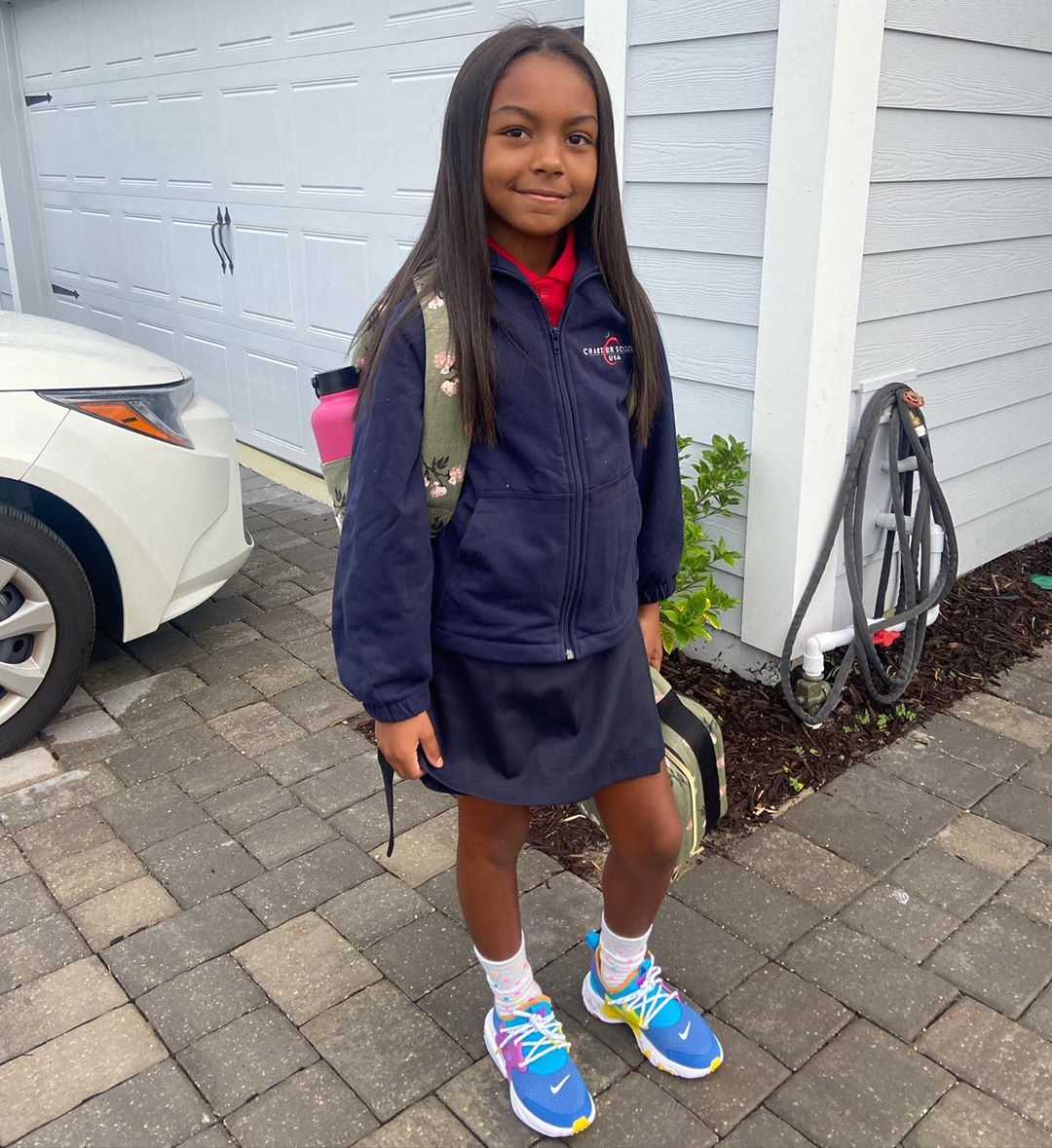 Stormi Webster wears a pink Hermès Kelly backpack to her first day