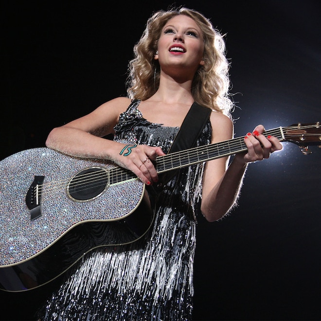 Taylor Swift performing with number 13 on hand