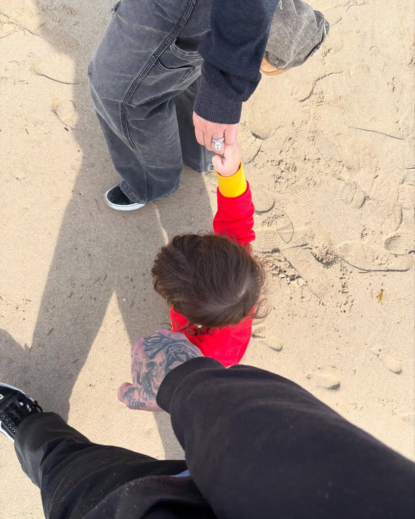 Kourtney Kardashian, Travis Barker and Rocky Barker walk down the beach while holding hands