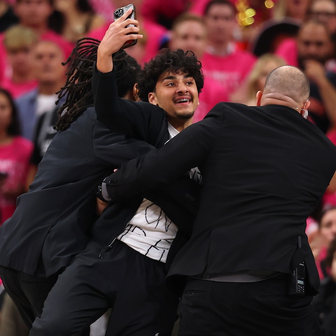 A fan is detained by security after running on the court during the fourth quarter of Game One of the 2026 NBA Finals